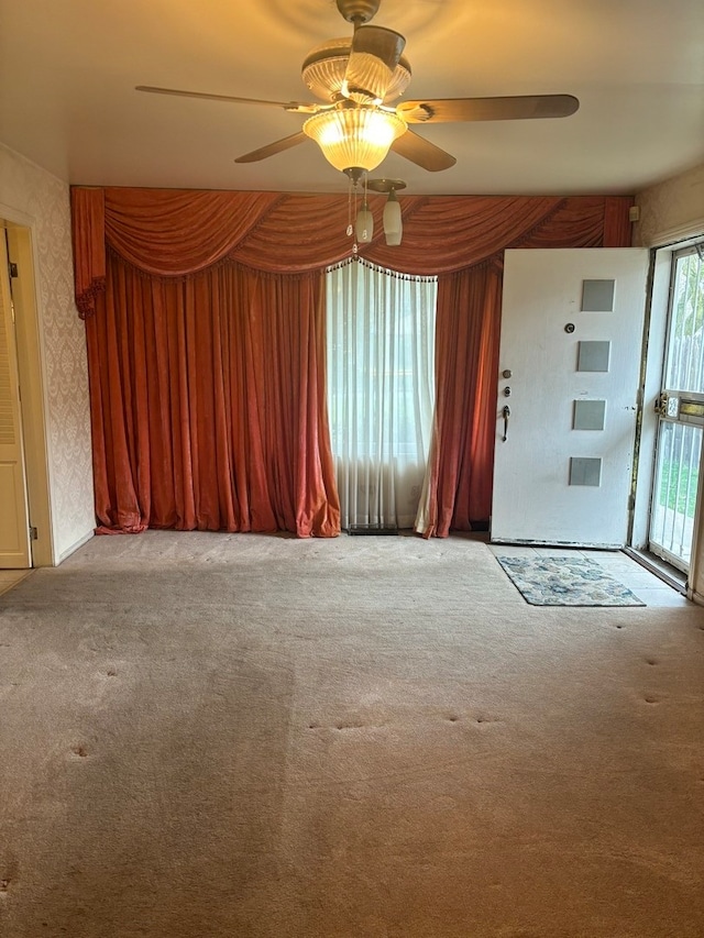 unfurnished room with ceiling fan and light carpet