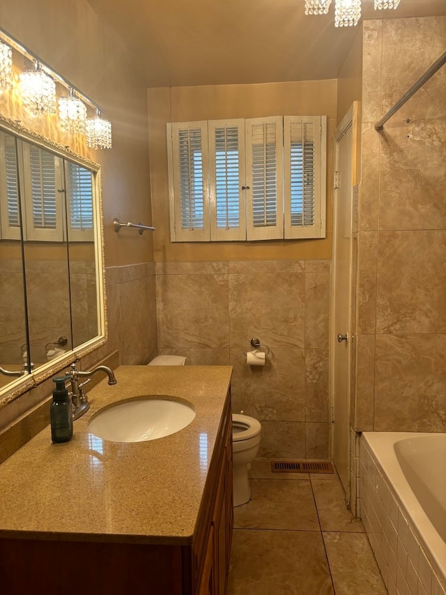 full bathroom with tile patterned floors, vanity, tile walls, and toilet