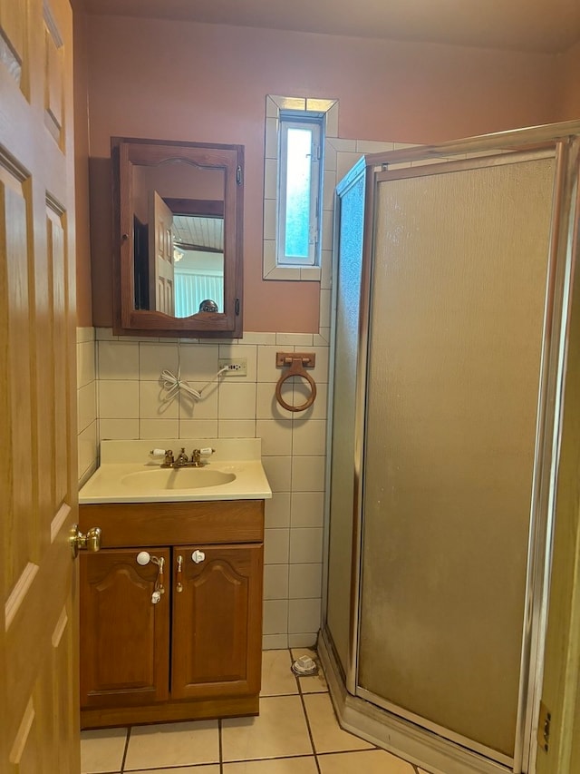 bathroom with tile patterned floors, vanity, walk in shower, and tile walls