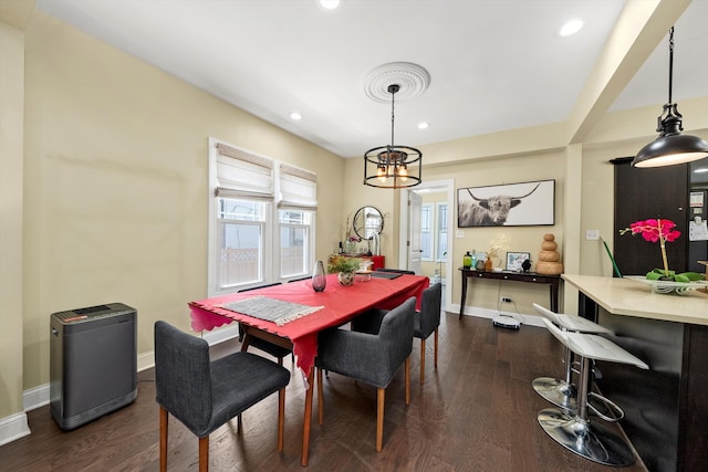 dining area with dark wood-type flooring and an inviting chandelier