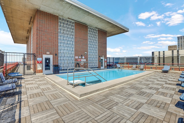 view of pool with a hot tub and a patio area