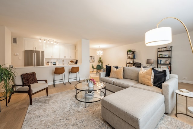 living room with light hardwood / wood-style flooring and a chandelier