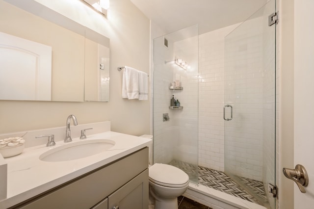 bathroom featuring toilet, an enclosed shower, and vanity