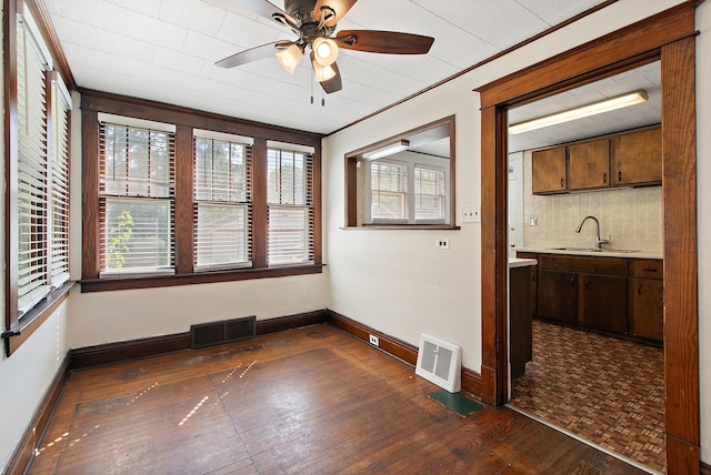 empty room featuring ceiling fan, crown molding, sink, and dark hardwood / wood-style flooring