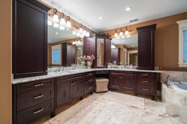 bathroom with tile patterned flooring, vanity, and a relaxing tiled tub