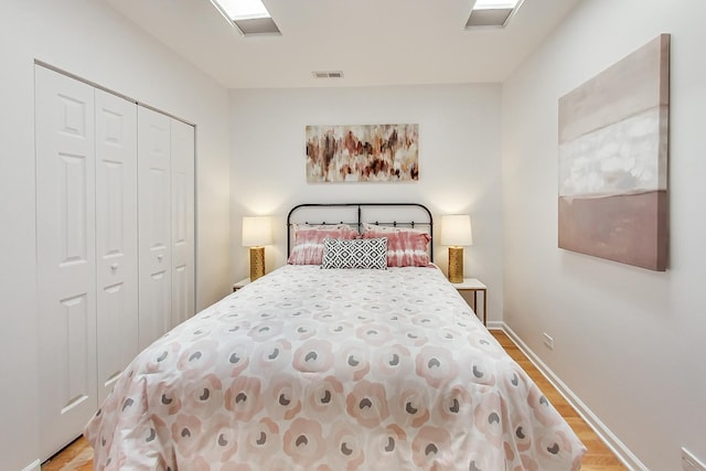 bedroom with light hardwood / wood-style flooring and a closet