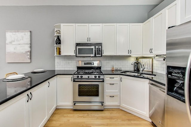 kitchen with white cabinetry, sink, backsplash, and appliances with stainless steel finishes