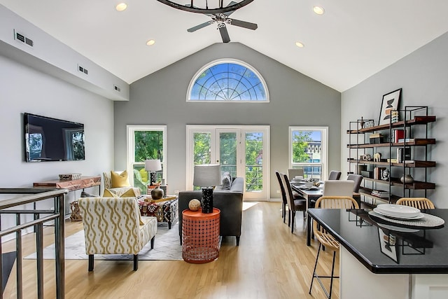 living room featuring ceiling fan, lofted ceiling, and light hardwood / wood-style floors