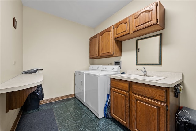 clothes washing area featuring cabinets, sink, and washing machine and dryer