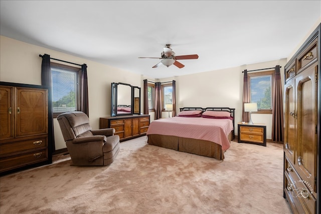 carpeted bedroom featuring ceiling fan and multiple windows