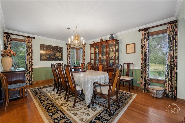 dining room with an inviting chandelier, a healthy amount of sunlight, and hardwood / wood-style flooring