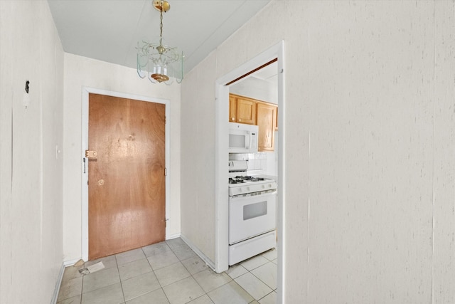 interior space with light tile patterned flooring and an inviting chandelier