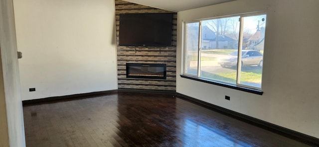 unfurnished living room featuring wood-type flooring, a large fireplace, and lofted ceiling