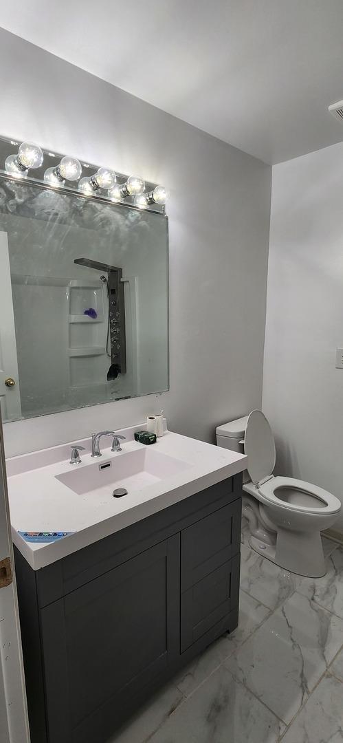 bathroom featuring vanity and toilet