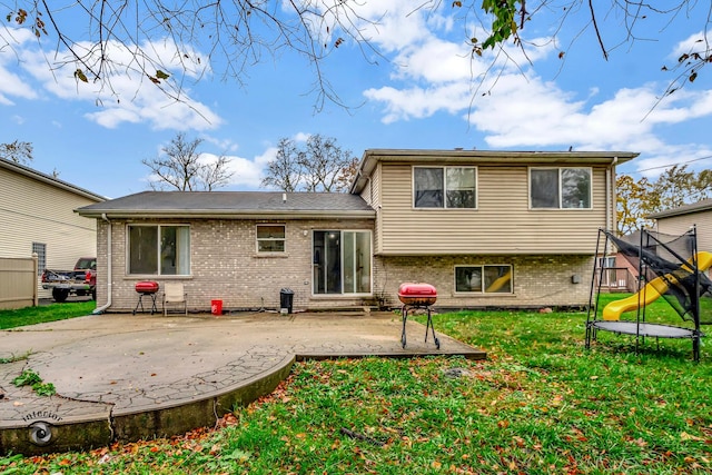 back of property with a trampoline and a patio area