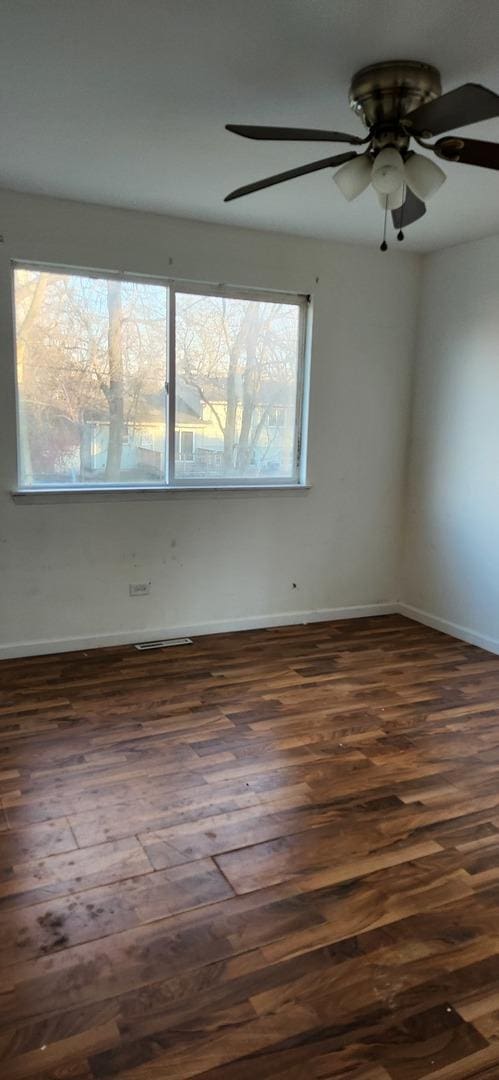 unfurnished room with ceiling fan and dark hardwood / wood-style flooring