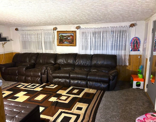 living room with carpet, wood walls, and a textured ceiling