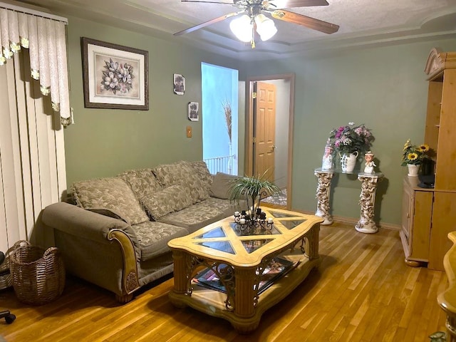 living room with a textured ceiling, light hardwood / wood-style floors, and ceiling fan