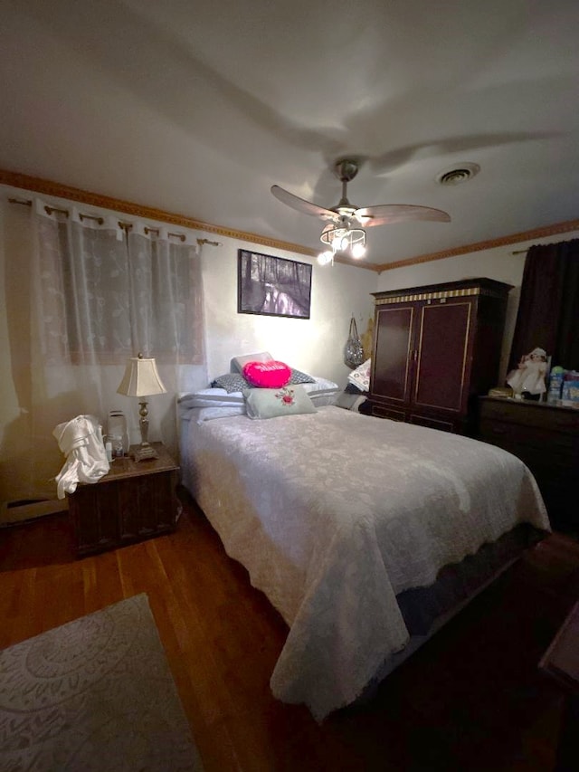 bedroom with dark hardwood / wood-style floors and ceiling fan