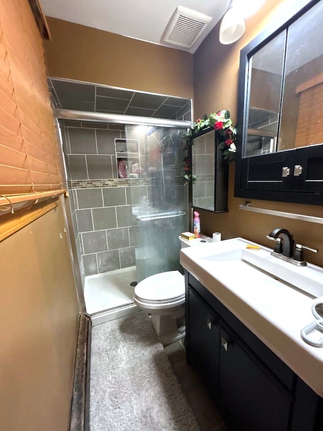 bathroom with toilet, a shower with shower door, and vanity