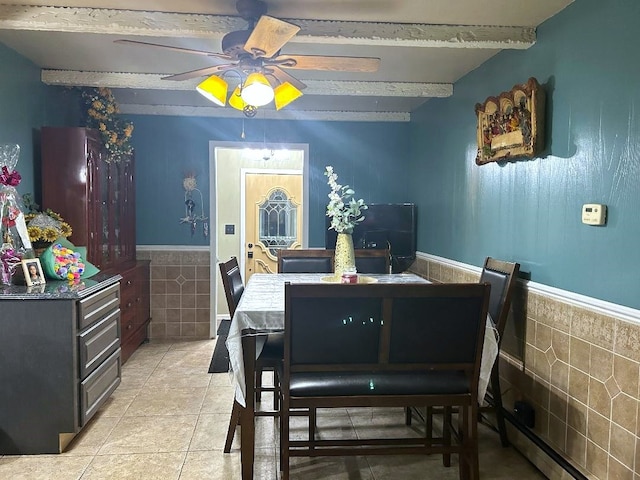 tiled dining room featuring beam ceiling, tile walls, a baseboard heating unit, and ceiling fan