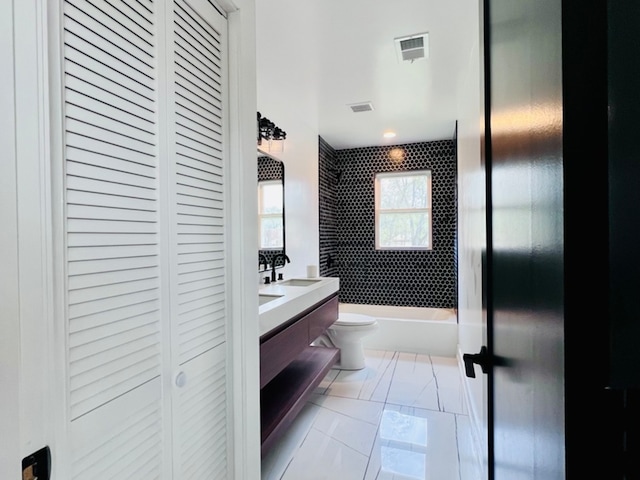 full bathroom with tile patterned flooring, vanity, toilet, and tiled shower / bath