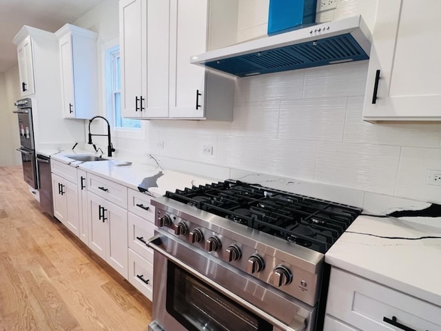 638 E 65th St, Chicago, IL 60637 - kitchen with wall chimney exhaust hood, stainless steel range, light wood-style flooring, white cabinets, and backsplash