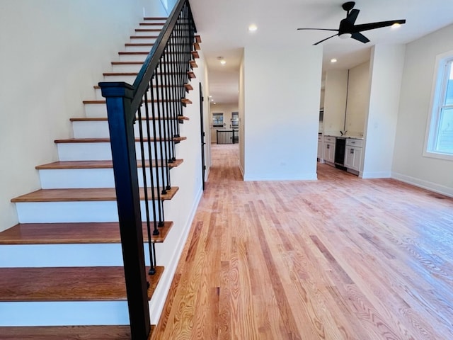 stairway featuring hardwood / wood-style flooring and ceiling fan