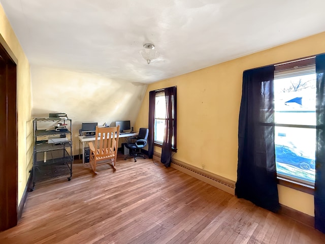 office space featuring baseboard heating and wood-type flooring