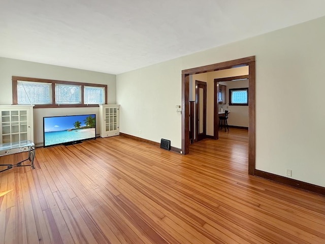 103 E Roosevelt St, Freeport, IL 61032 - unfurnished living room with light wood-style floors, baseboards, and healthy amount of natural light