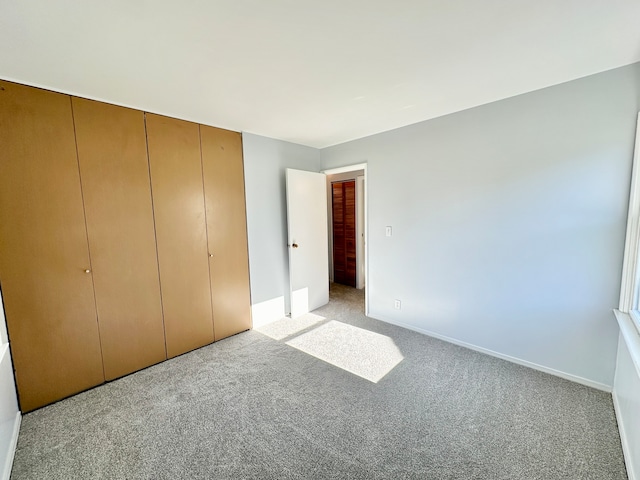 unfurnished bedroom featuring a closet and light carpet