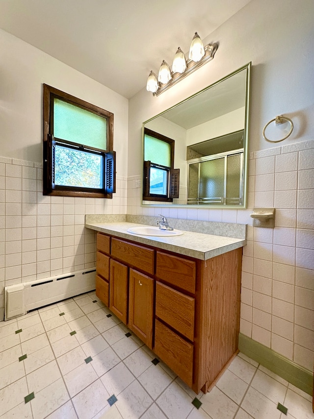 bathroom featuring baseboard heating, vanity, tile patterned flooring, and tile walls