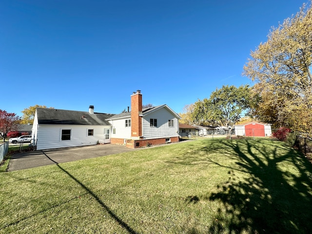 rear view of property featuring a patio and a lawn