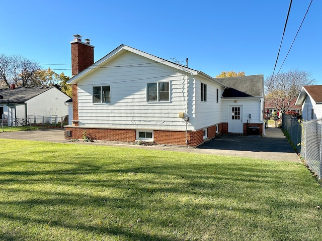 back of house featuring a patio area and a lawn