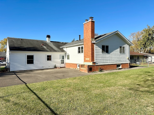 back of house featuring a patio area and a lawn