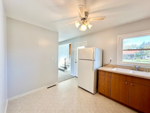 kitchen featuring white fridge, sink, and ceiling fan