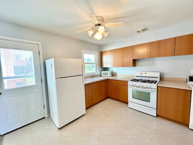 kitchen featuring white appliances, ceiling fan, and sink