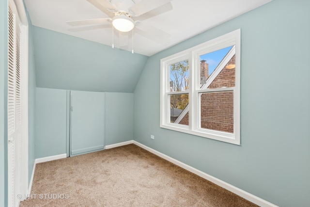 additional living space with light colored carpet, ceiling fan, and lofted ceiling