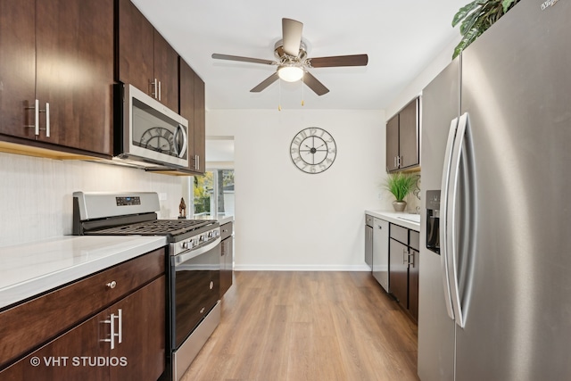 kitchen featuring dark brown cabinetry, ceiling fan, stainless steel appliances, and light hardwood / wood-style floors