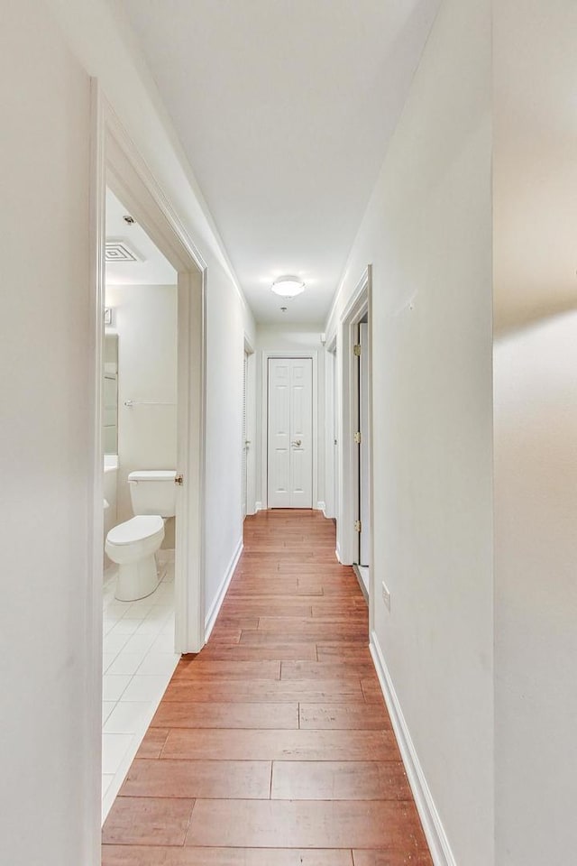 corridor with light hardwood / wood-style flooring