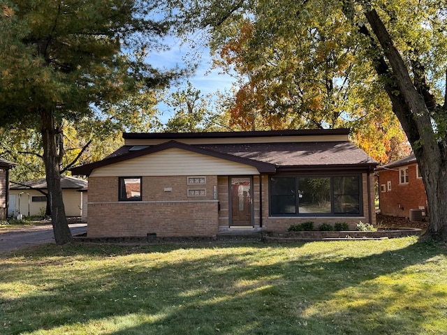 view of front of home with a front yard and central AC