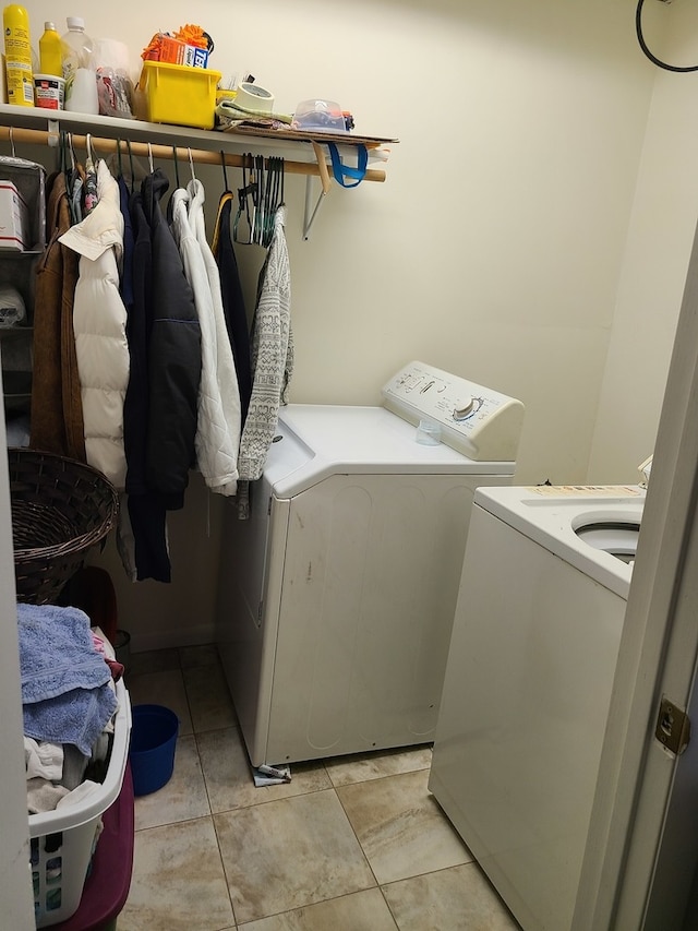 laundry area with washer and dryer and light tile patterned floors