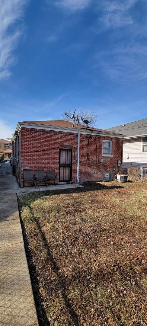 view of property exterior featuring central AC unit and a lawn