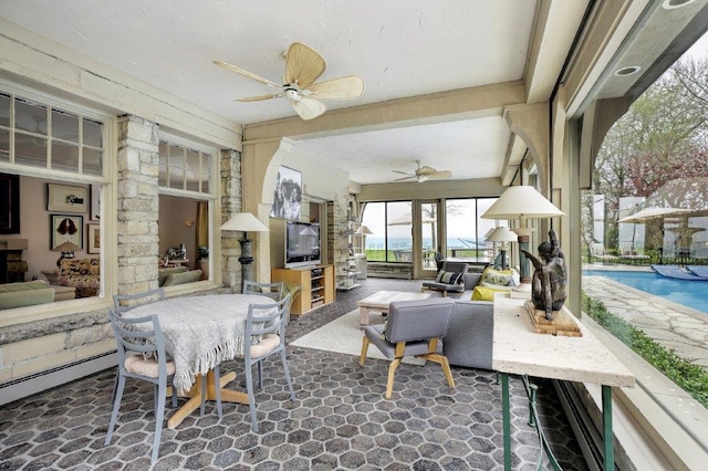 interior space featuring an outdoor living space with a fireplace and ceiling fan