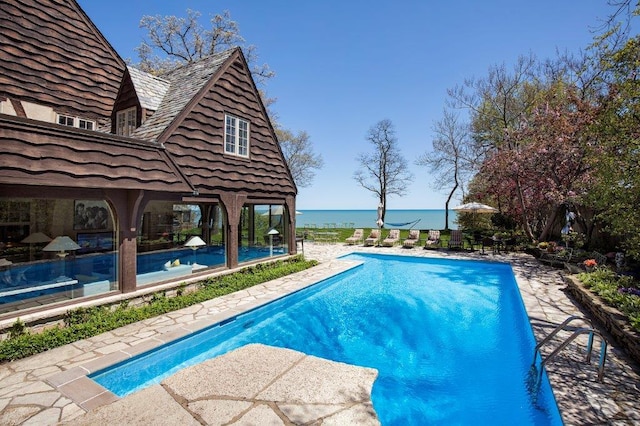 view of swimming pool featuring a patio area and a water view