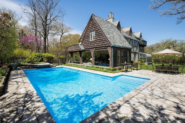 view of pool with a patio and a sunroom