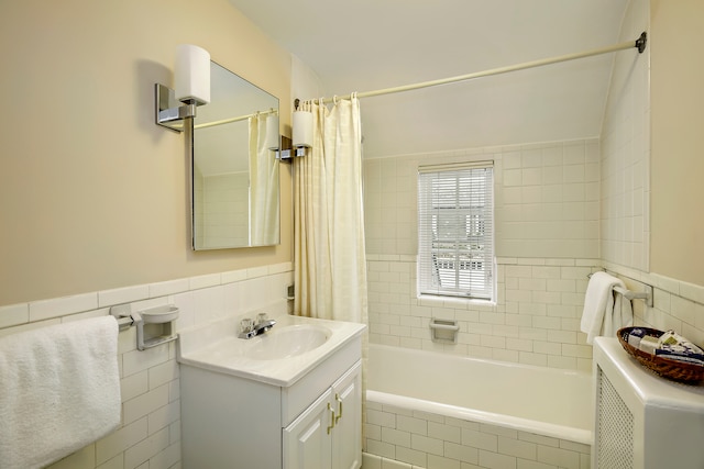 bathroom with shower / bath combination with curtain, vanity, and tile walls