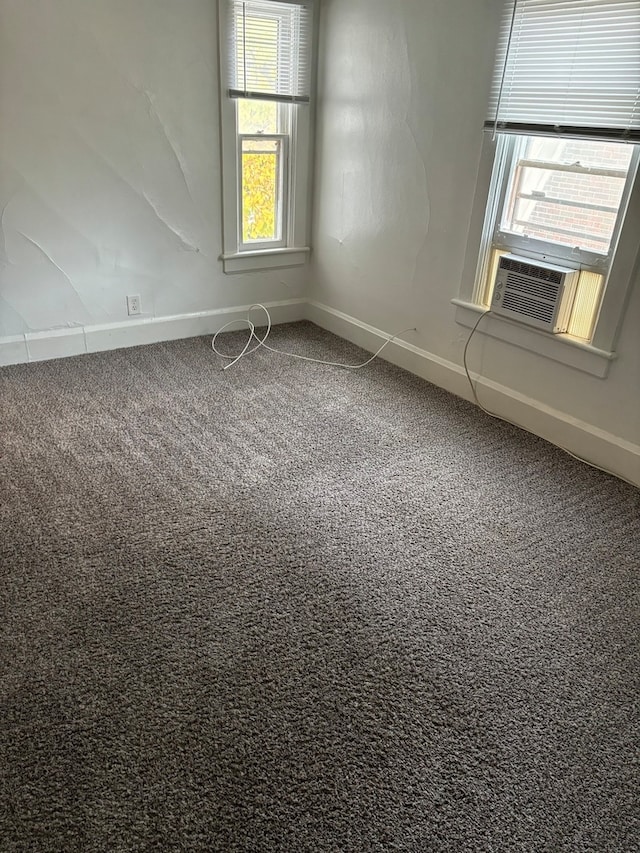 unfurnished room with cooling unit, carpet flooring, and plenty of natural light