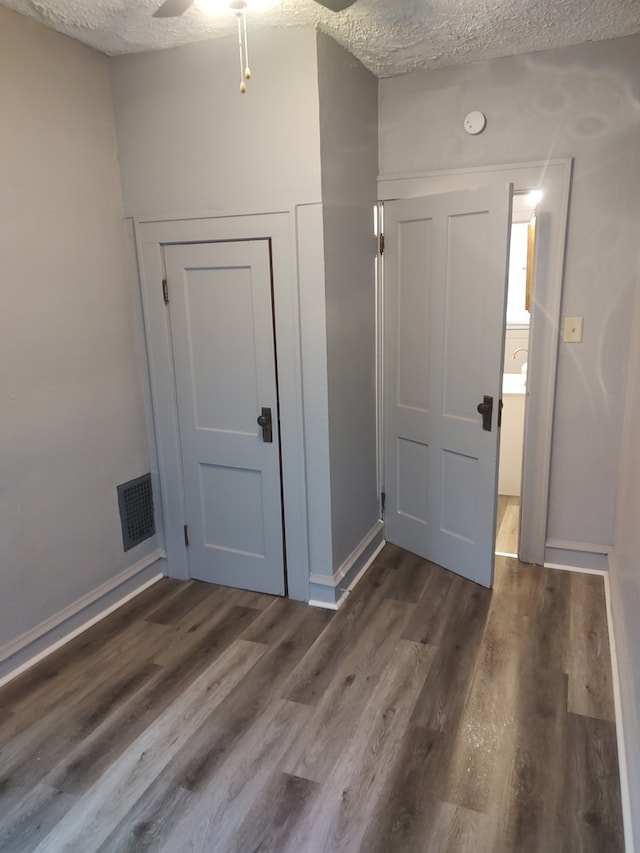 entrance foyer with a textured ceiling and dark hardwood / wood-style flooring