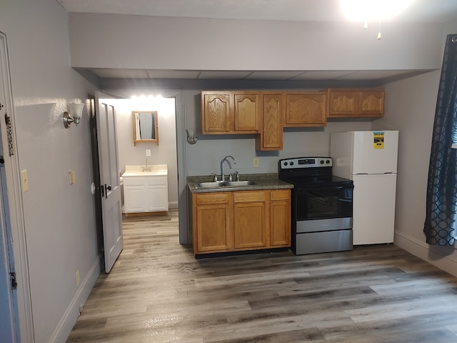 kitchen with sink, white fridge, stainless steel electric range, and hardwood / wood-style flooring